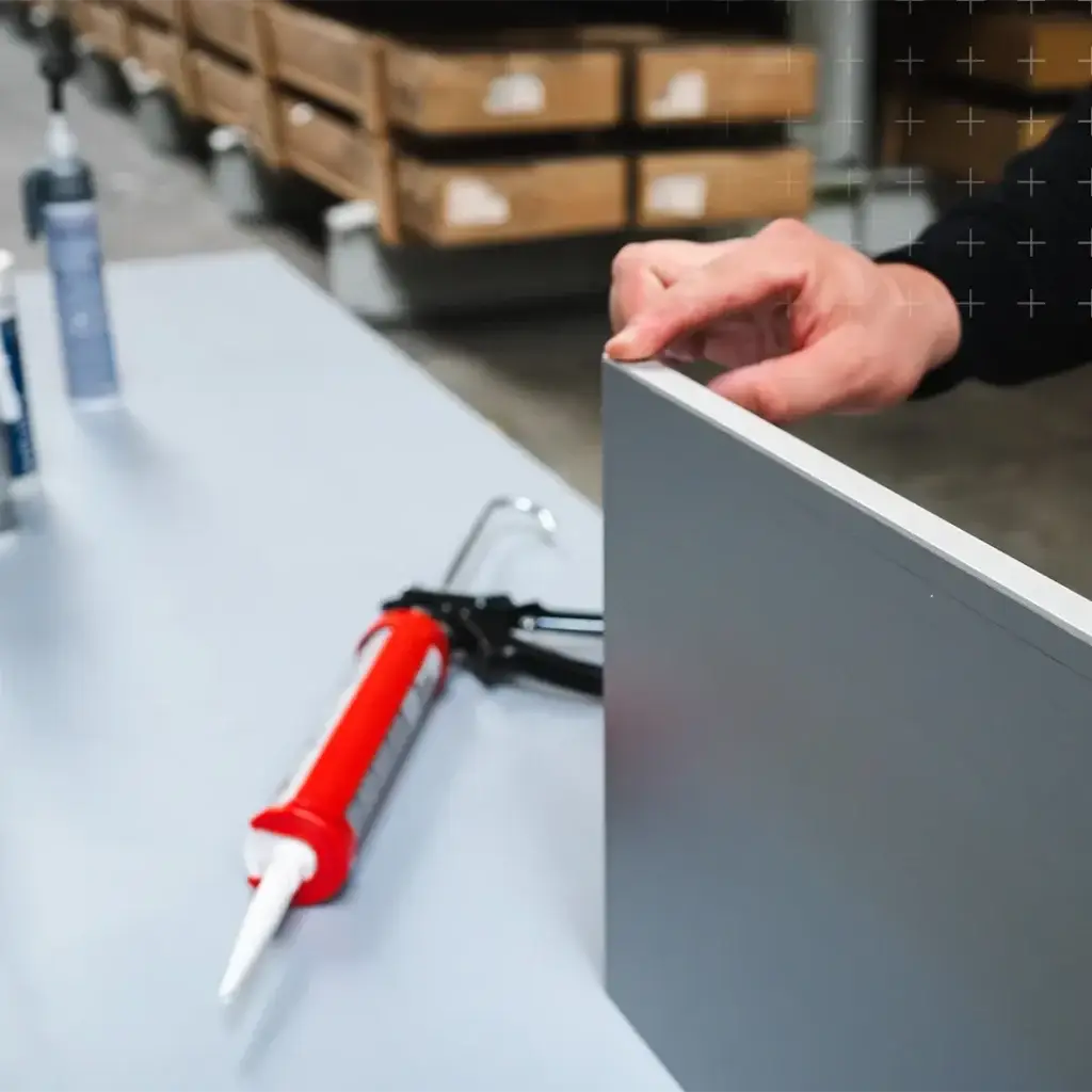 Lagermitarbeiter klebt ein Verbundplattenprofil an eine Aluminium-Verbundplatte