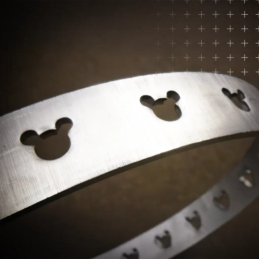 Ein Ring aus Aluminium mit ausgestanzten Micky Maus Figuren, sogenannten Hidden Mickeys