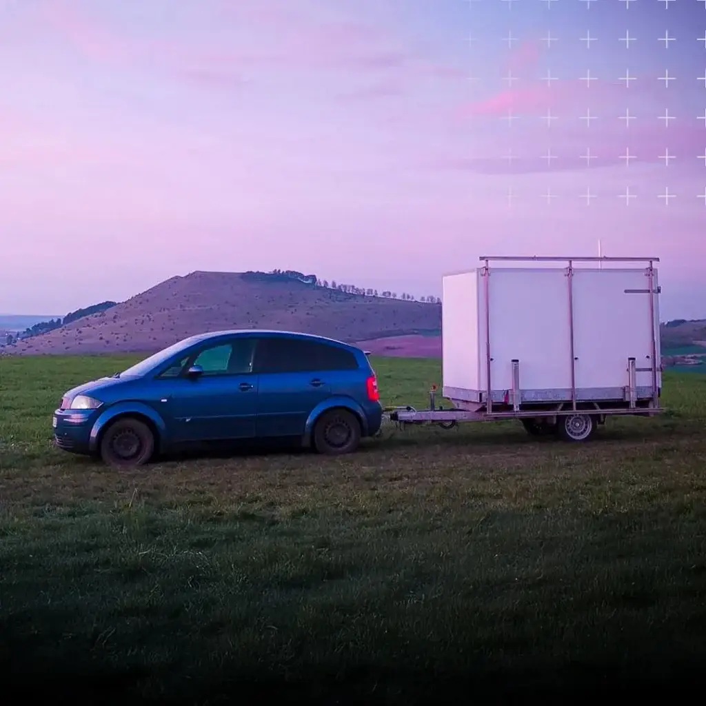 Anhänger-Container wird von einem Auto transportiert