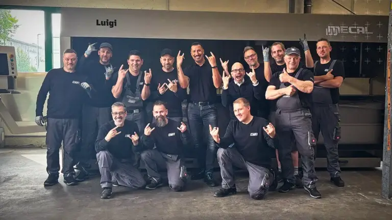 Lagermitarbeiter posieren vor einer CNC-Stabbearbeitungsmaschine